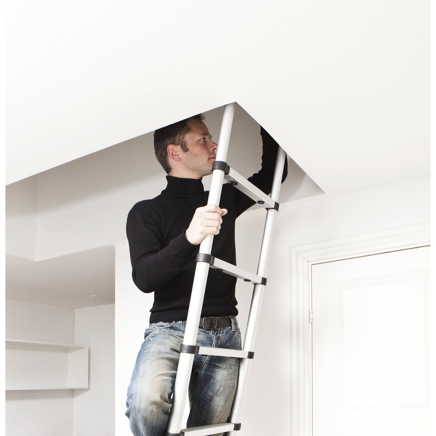 אדם מטפס בסולם לעליית גג בבית.