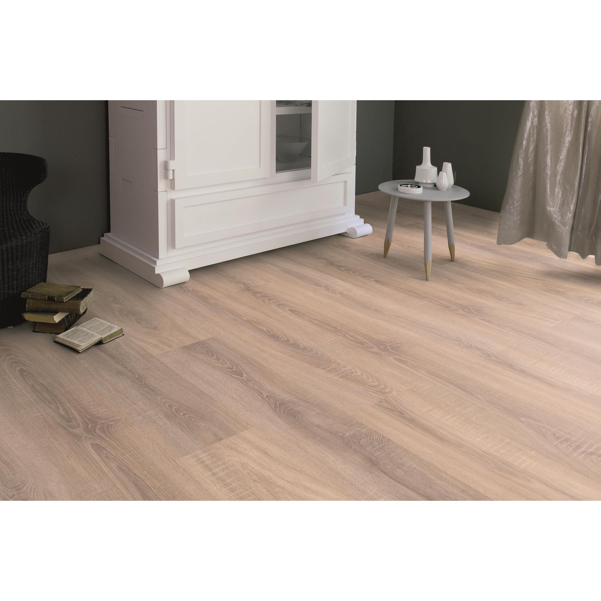 ארון לבן עומד ליד שולחן עגול בחדר.